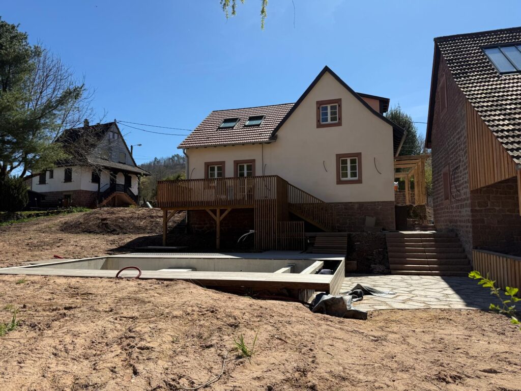 Terrasse sur pilotis surplombant un terrain en pente et une piscine à Obersteinbach, près de Niederbronn