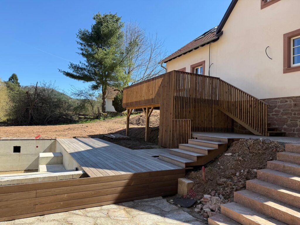 Terrasse autoportante en bois avec escalier menant à la plage de piscine sur terrain en pente
